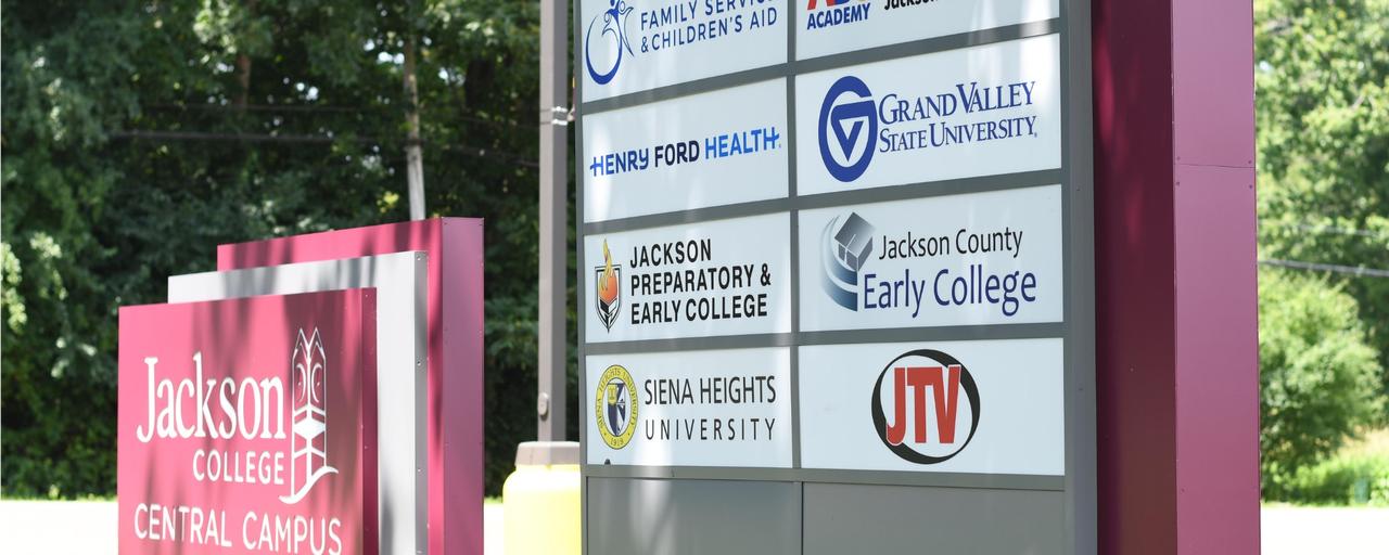 Jackson College road sign with GVSU banner